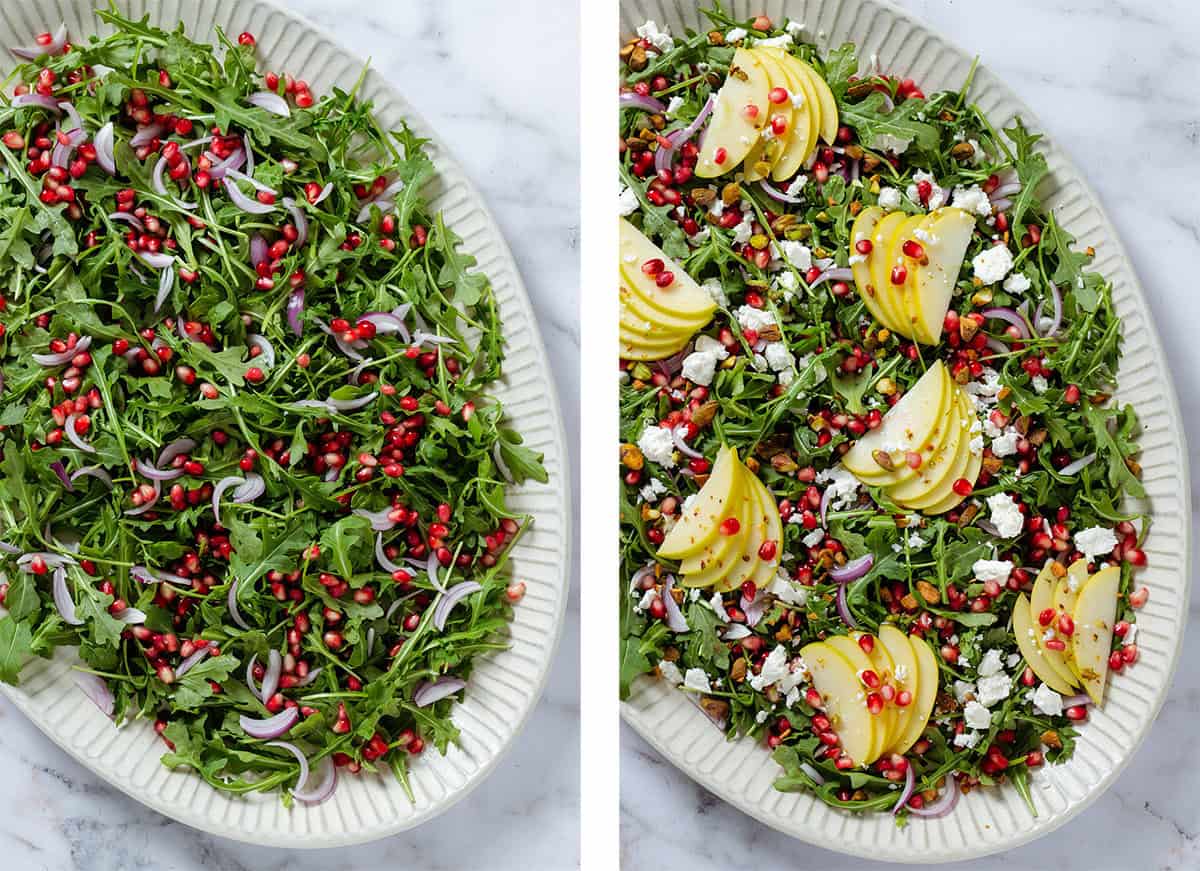 A large serving plate with arugula, pomegranate arils, and red onion on the left and with added apples and feta cheese on the right.