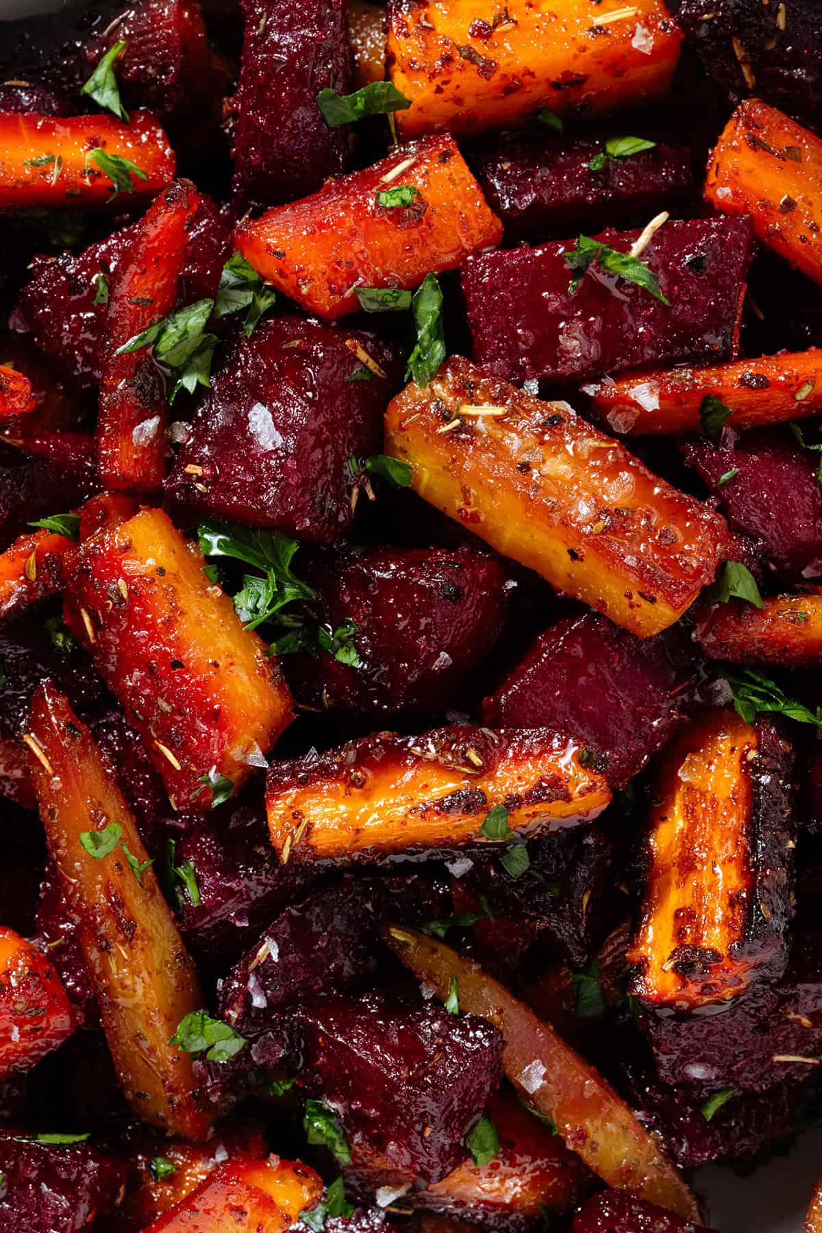 Caramelized roasted beets and carrots with balsamic vinaigrette garnished with chopped fresh parsley and flaky sea salt.