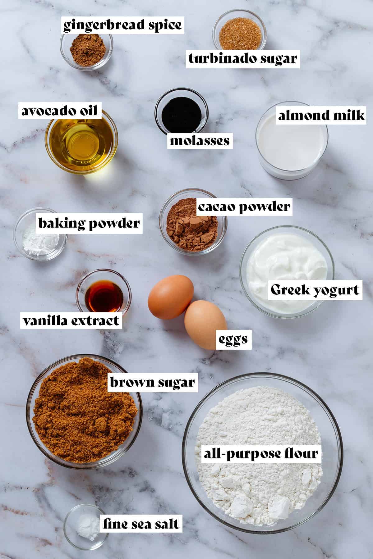 Small glass bowls with ingredients like brown sugar, flour, greek yogurt, cacao powder, and almond milk with text overlay.