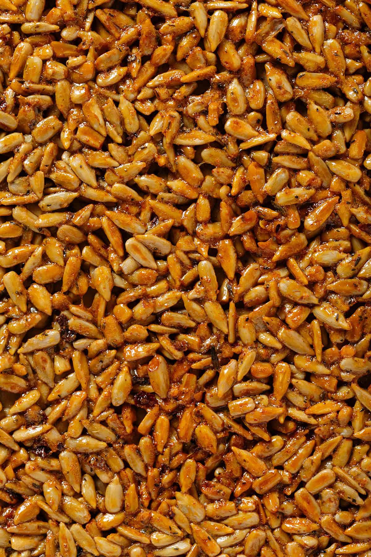 Golden honey roasted sunflower seeds stuck together in one big sheet before being broken up into small clusters.