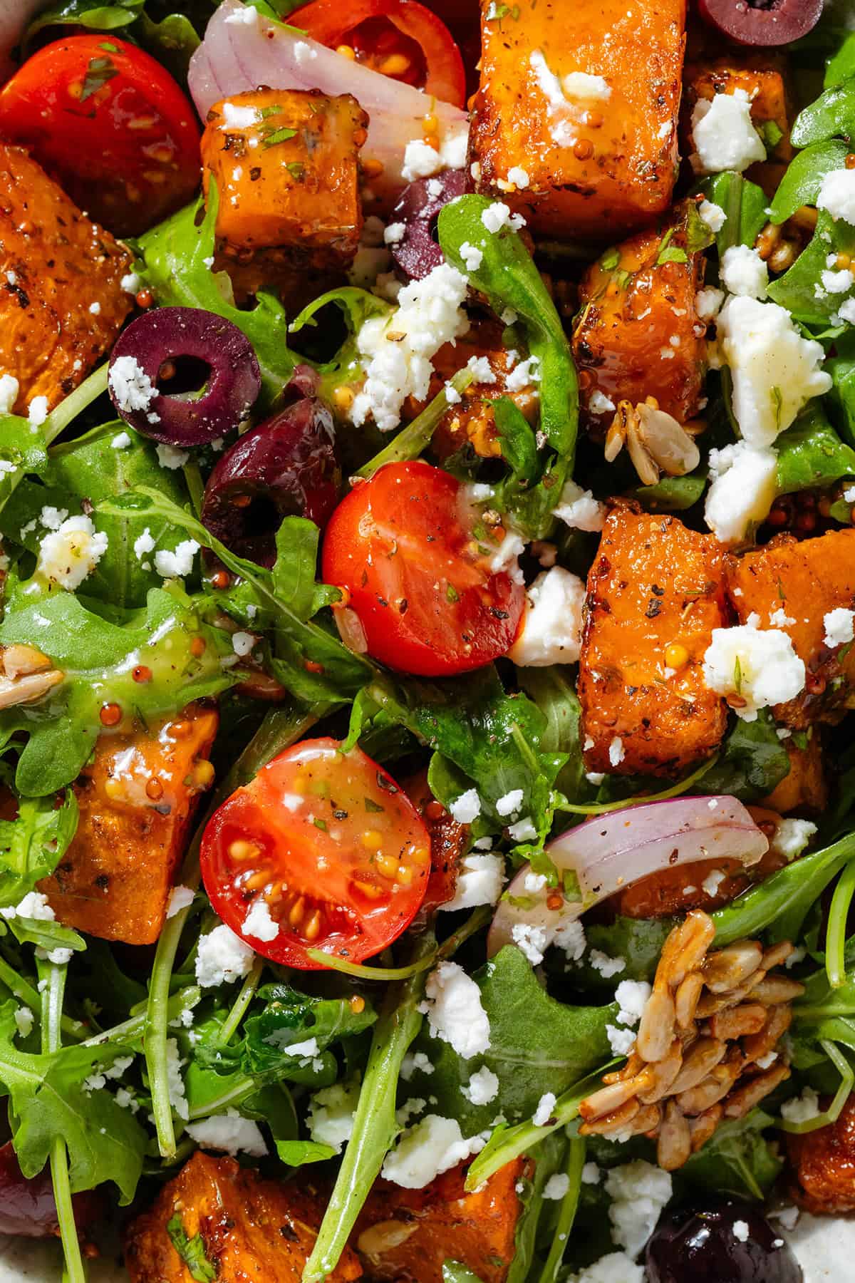 Arugula salad with diced roasted sweet potatoes with kalamata olives, feta, cherry tomatoes, sunflower seeds, and red onion drizzled with vinaigrette.