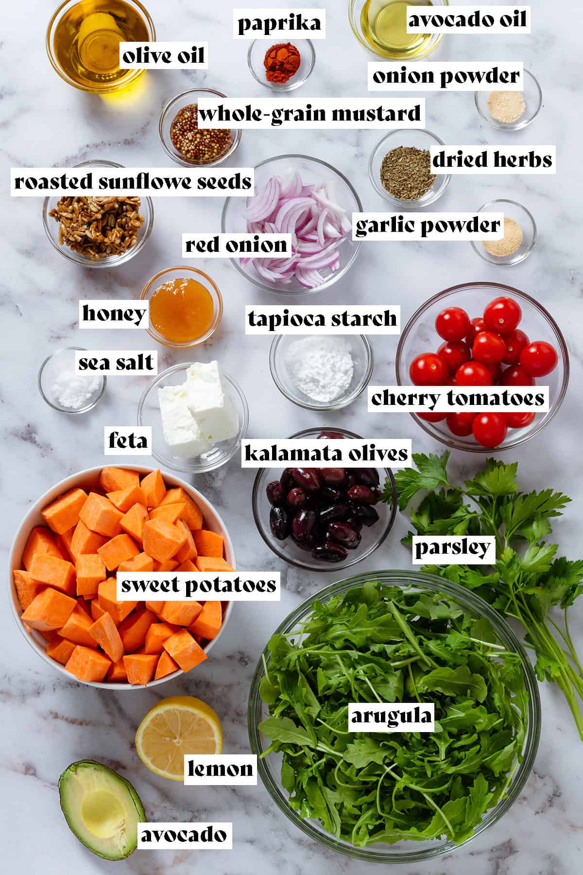 Glass bowls with ingredients like diced sweet potato, arugula, kalamata olives, cherry tomatoes, red onion, spices, feta, and olive oil with text overlay.