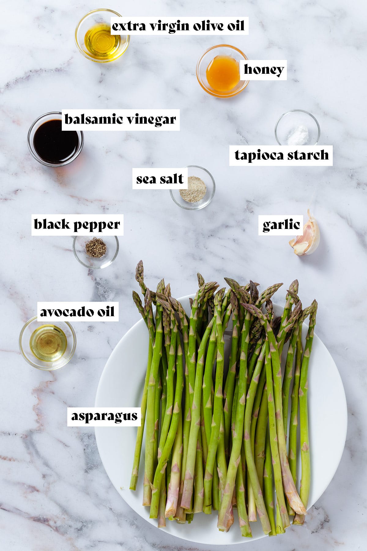 Ingredients like asparagus, balsamic vinegar, honey, olive oil, tapioca starch, and spices all measured and laid out in small bowls.