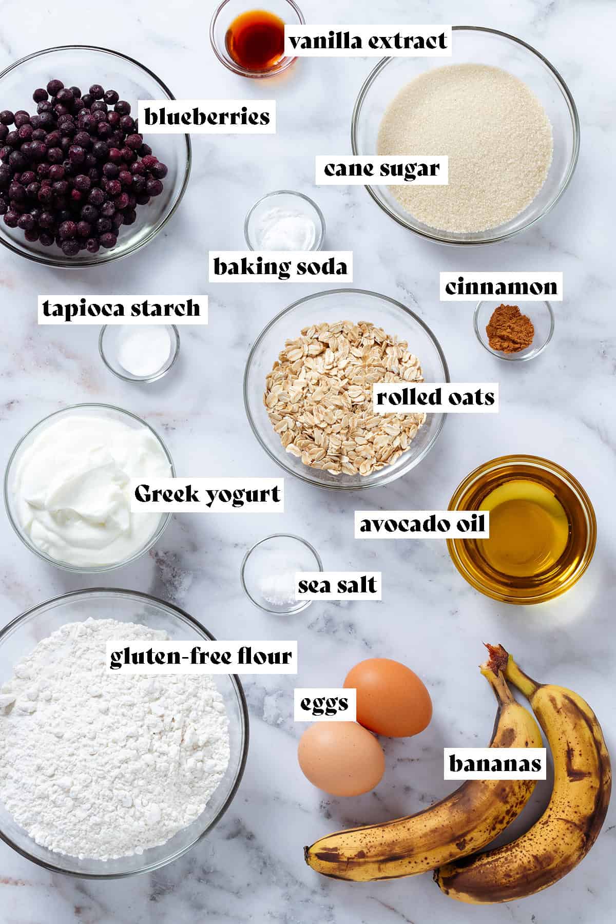 Ingredients like flour, sugar, yogurt, oats, and blueberries in small glass bowls with text overlay.