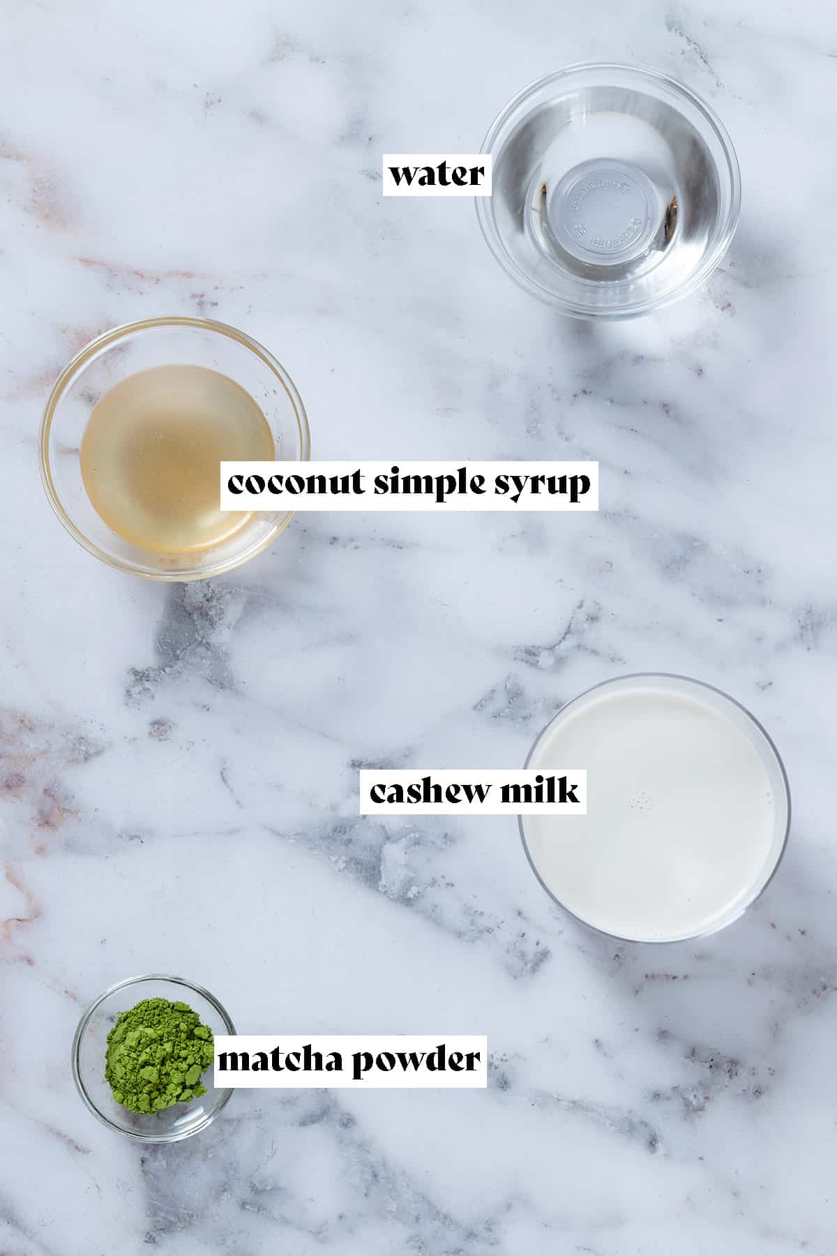 Small glass bowls with matcha powder, coconut syrup, water, and cashew milk.