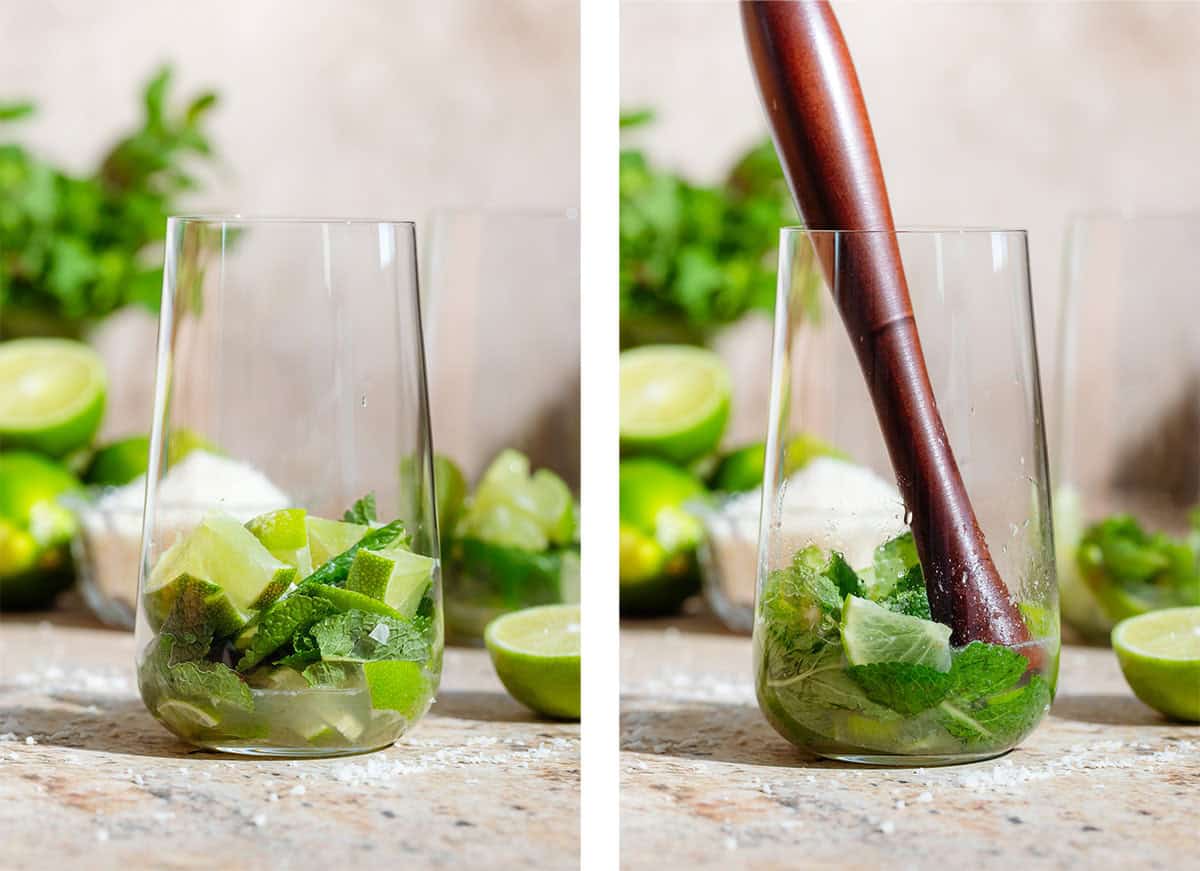 A tall glass with chopped lime, fresh mint leaves, and coconut syrup before and after muddling with a wooden muddler.
