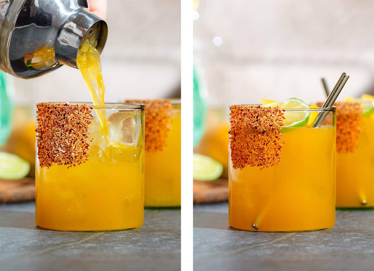 Mango margarita getting strained over ice into a short glass with tajin on the rim on the left, and garnished with lime and mango slices, and a gold straw on the right.