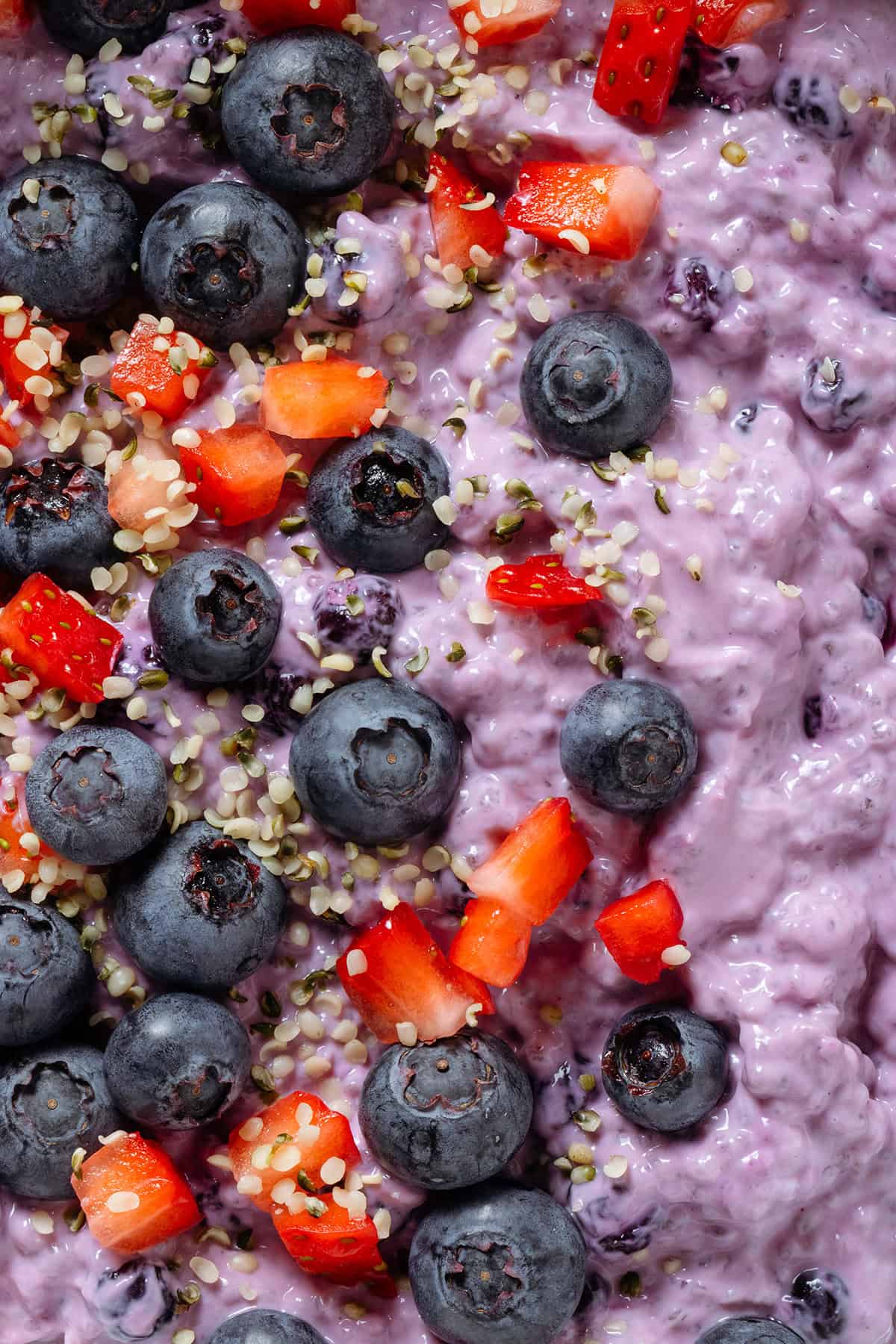 Blueberry chia pudding topped with fresh blueberries, diced strawberries, and seeds.