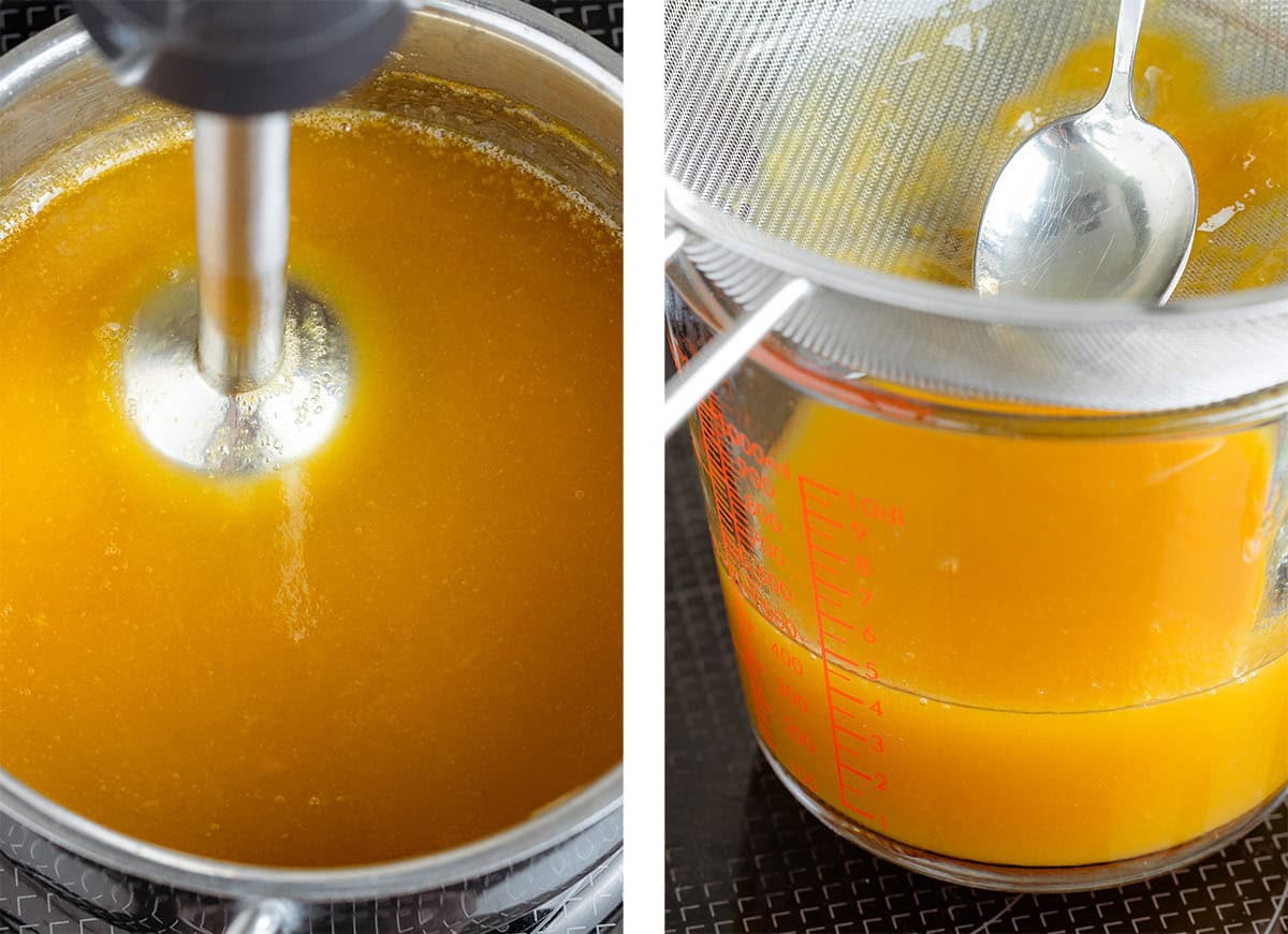 Bright yellow mango syrup being blended with an immersion blender and strained into a glass measuring up.