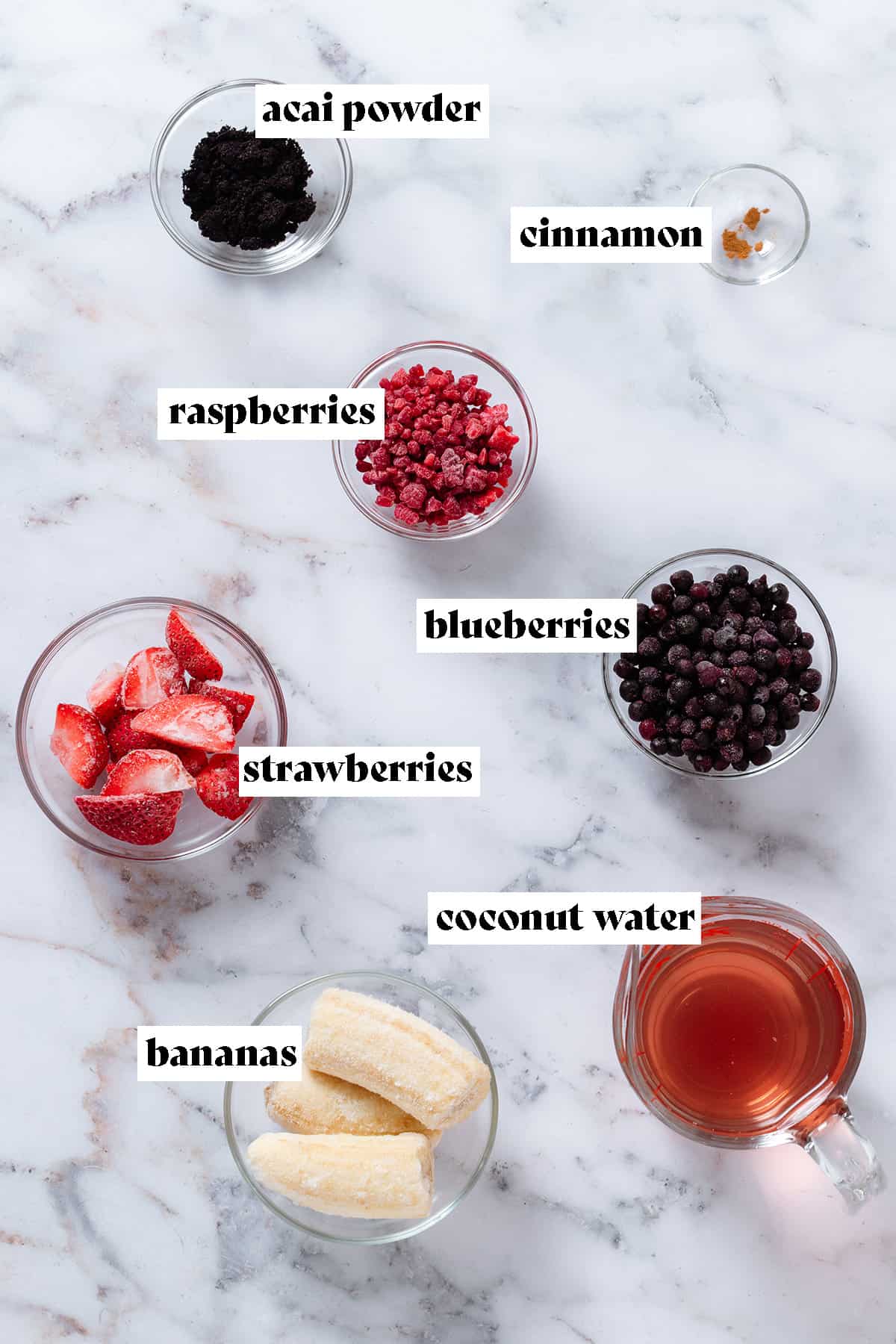 Ingredients like frozen berries, banana, coconut water, acai powder, and cinnamon in glass bowls with text overlay.