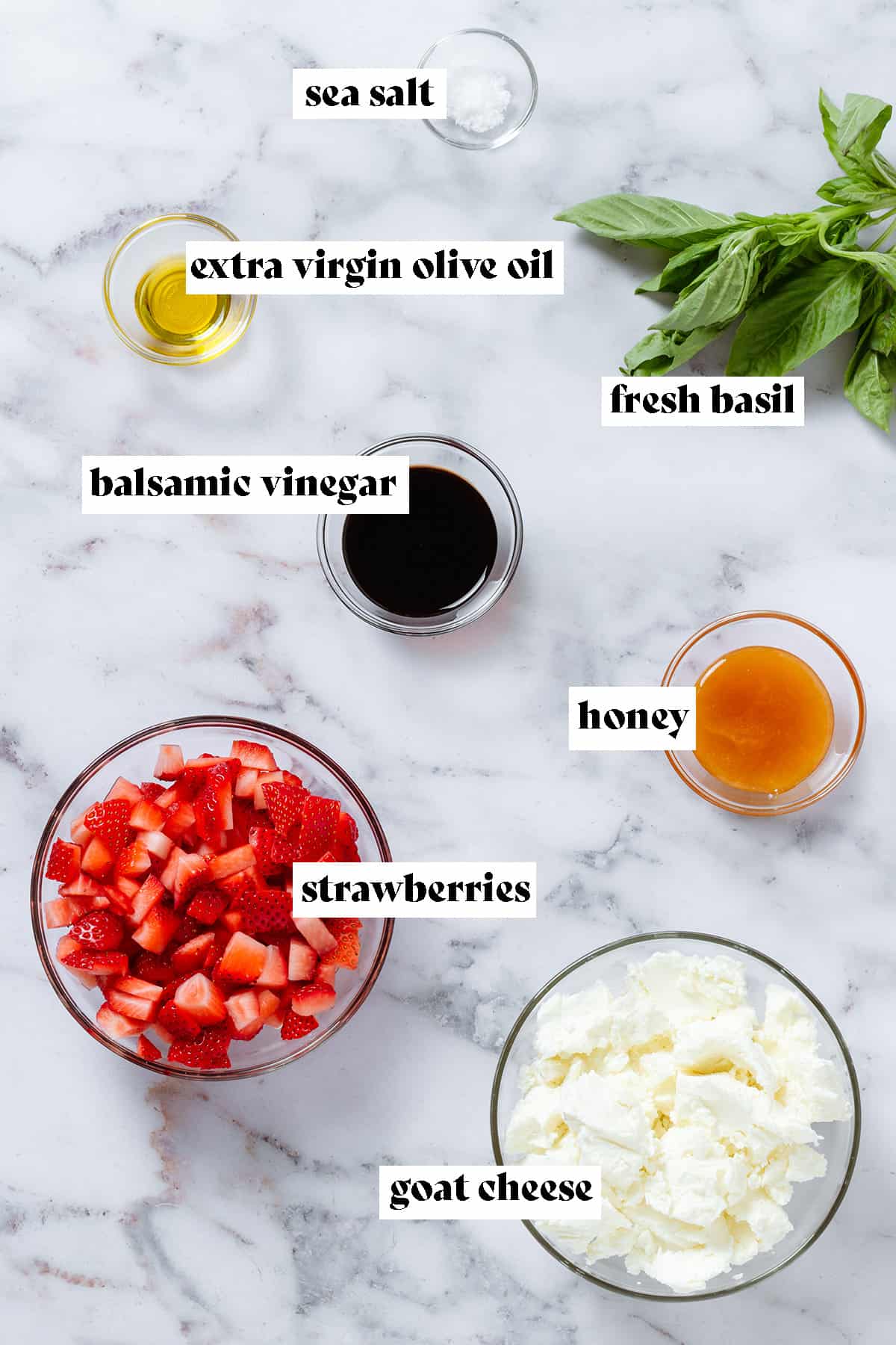 Ingredients like diced strawberries, soft goat cheese, honey, balsamic vinegar, and oil in small glass bowls with text overlay.