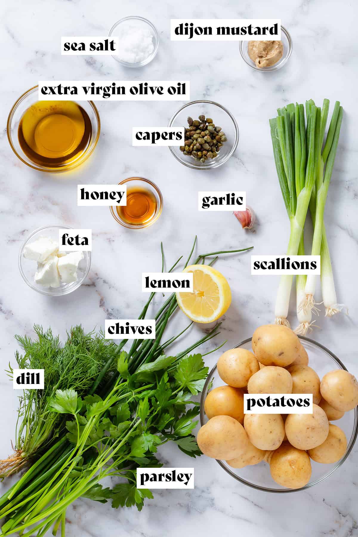Ingredients laid out like fresh herbs, scallions, baby potatoes, and glass bowls with olive oil, capers, honey, and feta with text overlay.