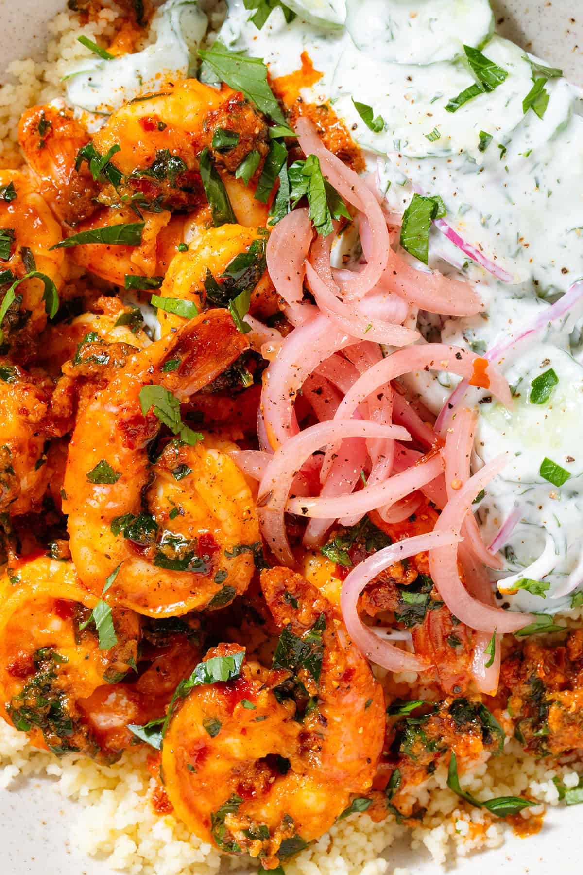 Bright orange harissa shrimp atop Moroccan couscous, with creamy cucumber salad and pickled red onion.