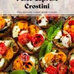Crostini with pesto, mozzarella, cherry tomatoes drizzled with balsamic glaze and garnished with fresh basil leaves and sprinkled with flaky sea salt.