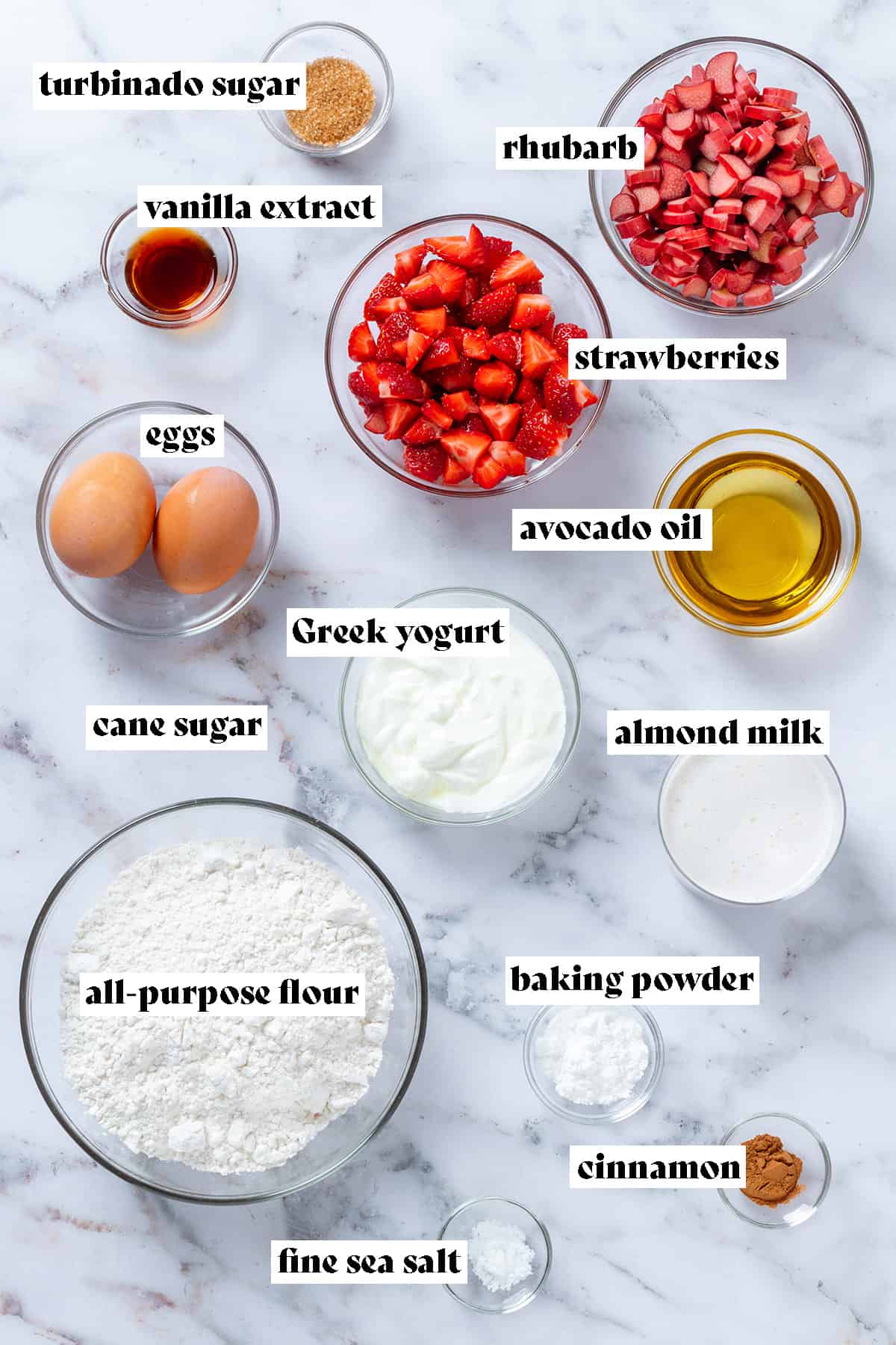 Ingredients in glass bowls like diced rhubarb, strawberries, eggs, oil, yogurt, milk, flour, and spices with text overlay.