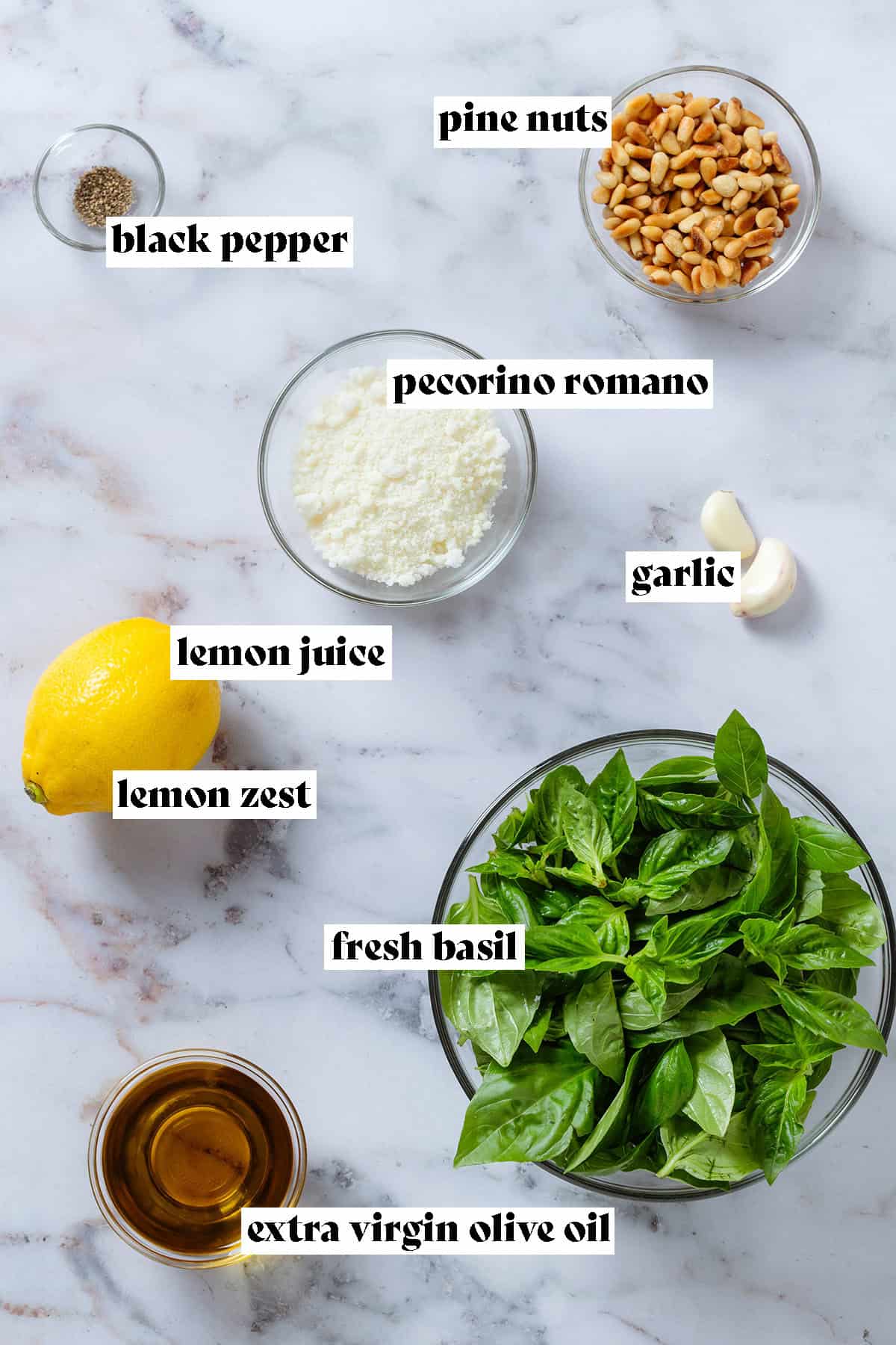 Ingredients in glass bowls like fresh basil, pecorino, pine nuts, and olive oil with text overlay.