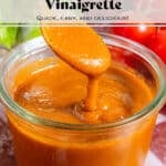 A glass jar of homemade blended sundried tomato vinaigrette and a spoon scooping it up to show how creamy it is.